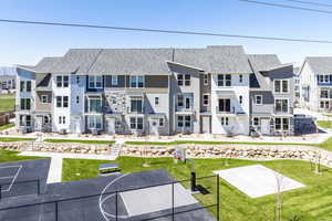 Rear view of property featuring basketball court and a yard