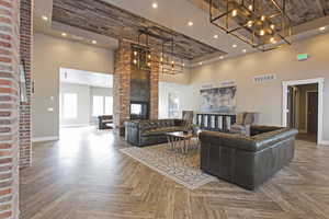 Living room with a high ceiling, parquet flooring, and a fireplace