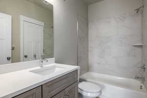 Full bathroom with vanity, toilet, and tiled shower / bath