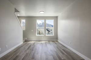 Unfurnished room featuring hardwood / wood-style flooring and a textured ceiling