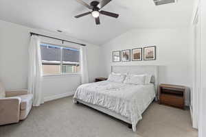 Carpeted bedroom featuring ceiling fan and lofted ceiling