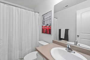 Bathroom featuring vanity, toilet, and a shower with shower curtain