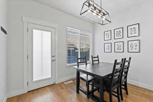 Dining space with wood-type flooring and a chandelier