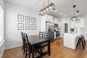 Dining space with sink and hardwood / wood-style floors