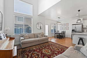 Living room with a towering ceiling and light hardwood / wood-style flooring