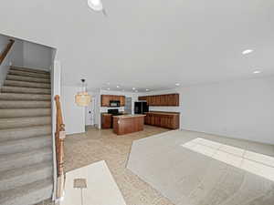 Kitchen featuring a center island, pendant lighting, and black appliances