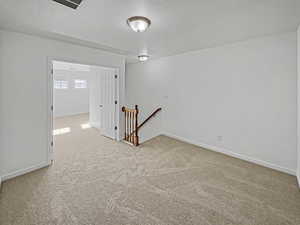 Empty room featuring carpet floors and a textured ceiling