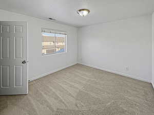 Carpeted empty room with a textured ceiling