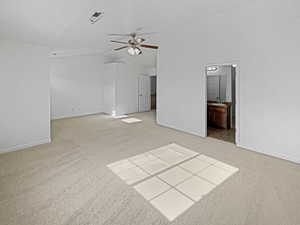 Carpeted empty room featuring vaulted ceiling, sink, and ceiling fan