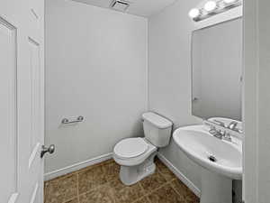 Bathroom with toilet, tile patterned flooring, and sink