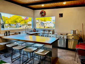 View of patio featuring a grill, an outdoor kitchen, and an outdoor wet bar