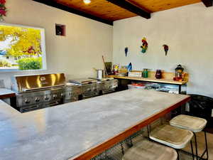 Kitchen with wood ceiling, a kitchen breakfast bar, and beam ceiling