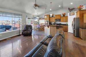 Living room featuring hardwood / wood-style flooring, vaulted ceiling, and a chandelier