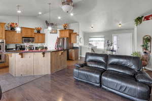 Kitchen featuring a kitchen island, decorative light fixtures, a breakfast bar area, and appliances with stainless steel finishes