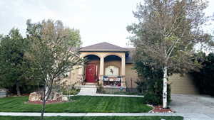 View of front of home with a garage and a front lawn