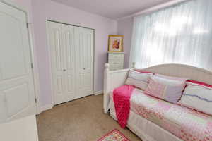 Carpeted bedroom with a closet