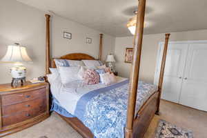 Bedroom featuring a closet, ceiling fan, and carpet