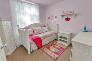 Bedroom featuring light colored carpet