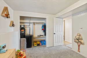 Carpeted bedroom featuring a closet and a textured ceiling