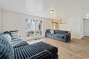 Living room with wood-type flooring and a textured ceiling