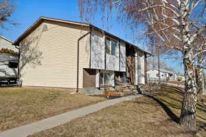 View of side of home featuring a yard