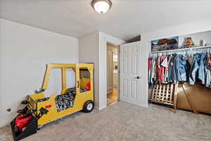 Bedroom featuring carpet flooring, a closet, and a textured ceiling