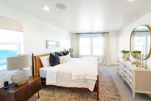 Carpeted bedroom featuring multiple windows