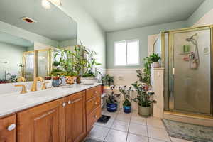 Bathroom with walk in shower, tile patterned floors, and vanity