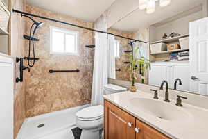 Bathroom with walk in shower, plenty of natural light, and vanity