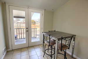 Tiled dining space with french doors and plenty of natural light