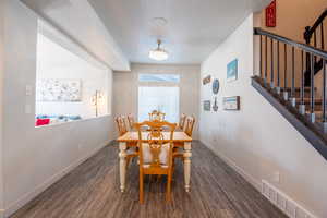 Dining area with dark hardwood / wood-style flooring