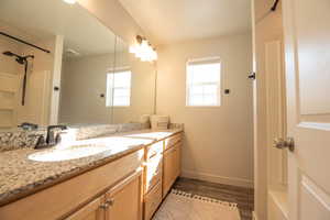 Bathroom with hardwood / wood-style flooring, vanity, and a shower