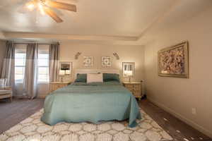 Bedroom featuring ceiling fan, a tray ceiling, and carpet flooring