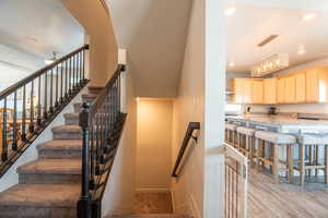 Stairs with ceiling fan and wood-type flooring