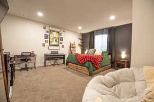 Bedroom featuring light carpet
