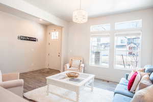 Living room with light hardwood / wood-style flooring and a chandelier