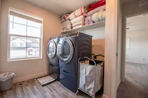 Laundry area featuring hardwood / wood-style flooring and washer and dryer