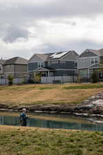 Exterior space featuring a residential view, a water view, and fence