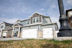 View of front of house with stone siding and a garage