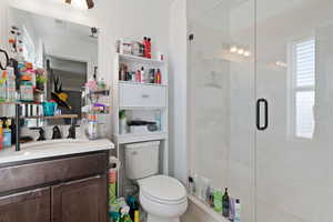 Bathroom with vanity, toilet, and walk in shower