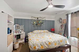 Carpeted bedroom featuring ceiling fan