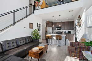 Living room with a towering ceiling and light wood-type flooring