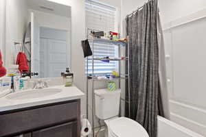 Full bathroom with vanity, toilet, and shower / tub combo with curtain