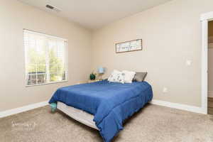 Bedroom featuring light carpet