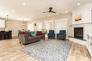 Living room with ceiling fan and light wood-type flooring