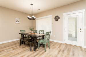 Dining space with plenty of natural light, a chandelier, and light hardwood / wood-style floors