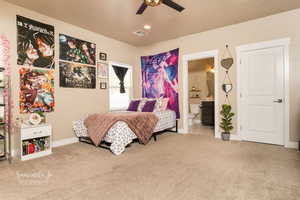 Bedroom with ensuite bathroom, light colored carpet, and ceiling fan