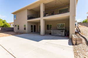 Back of property featuring a hot tub and a patio