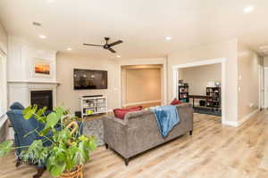 Living room with ceiling fan and light hardwood / wood-style floors