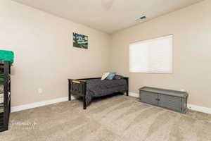 Bedroom featuring light carpet and a textured ceiling